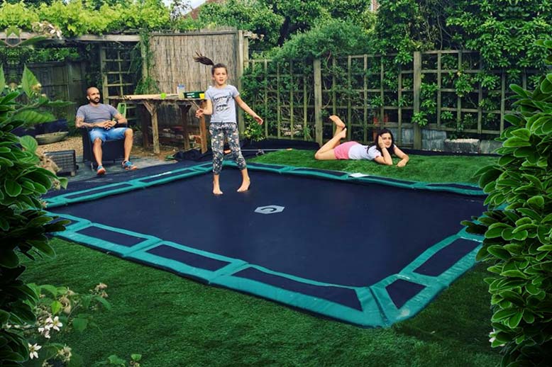 I bambini del trampolino interrato a livello del pavimento giocano