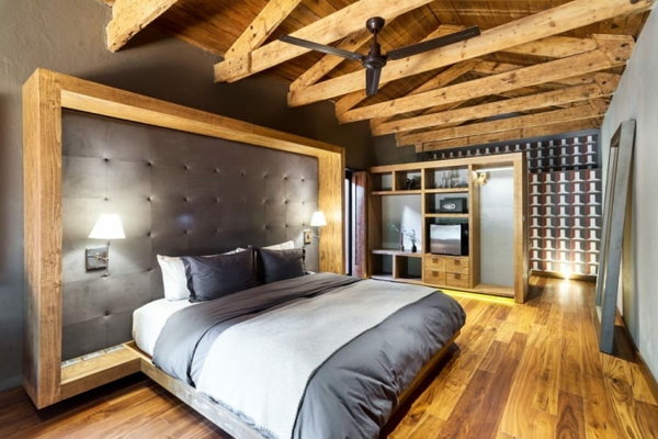 Les plafonds créent une chambre confortable avec des poutres en bois