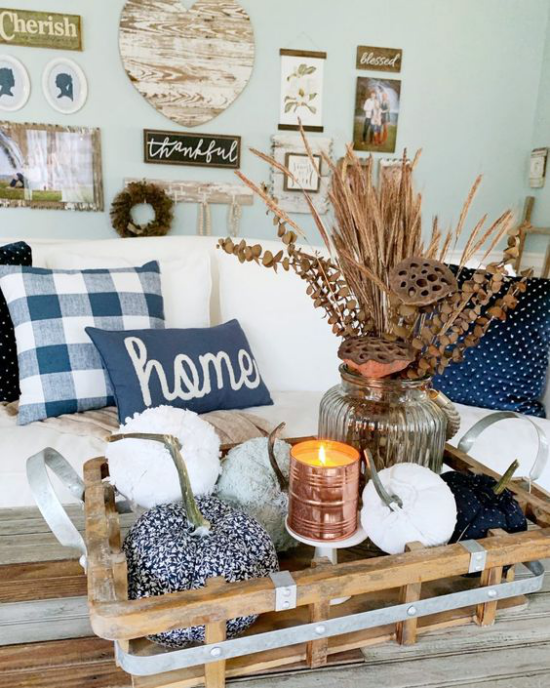 Illatos őszi gyertya dekoráció egy fából készült tálcán a dohányzóasztalon a nappaliban sok színben