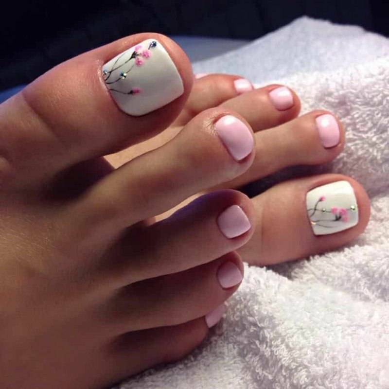 Disegno dell'unghia del piede con fiori bianchi rosa