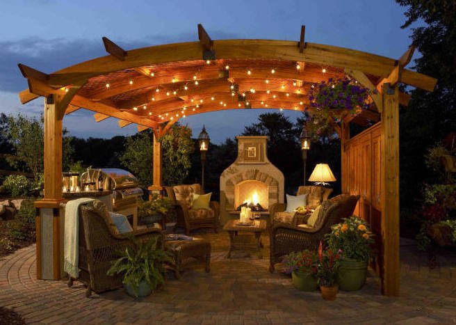 A megvilágított pergola készlet este romantikus hangulatot teremt kerti kandallóval kombinálva A megvilágított pergola készlet este romantikus hangulatot teremt kerti kandallóval kombinálva