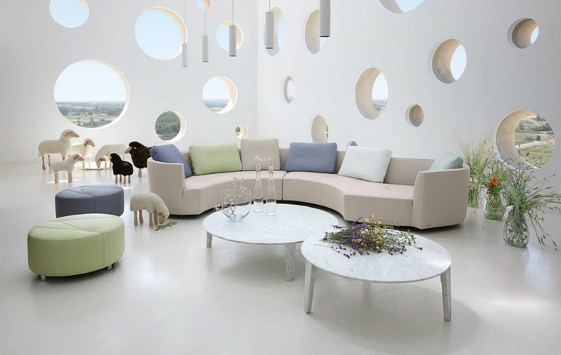polukružna sofa i elegantna dva stolića okrugla sofa bijeli šareni jastuci super moderan dnevni boravak