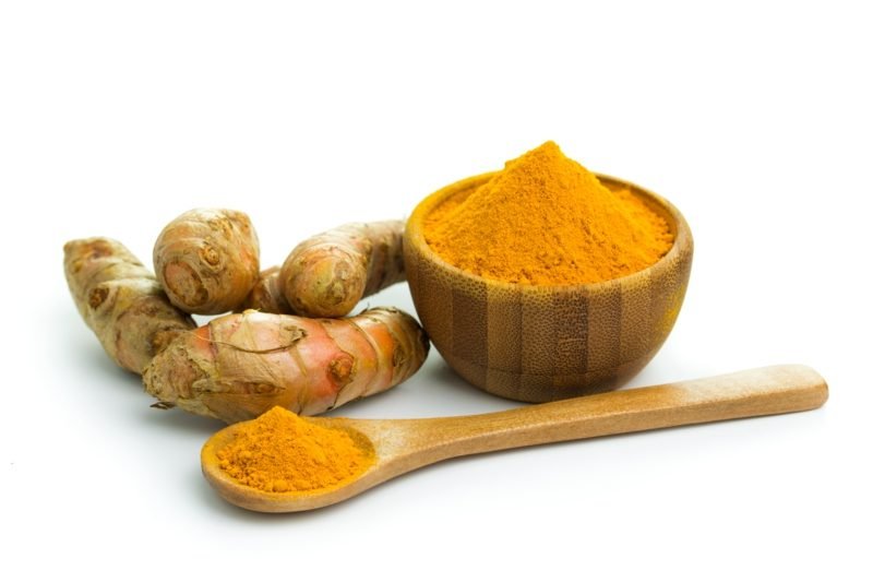 cuillère et bol de poudre de curry d'antibiotiques naturels poudre de curry antibiotique naturel