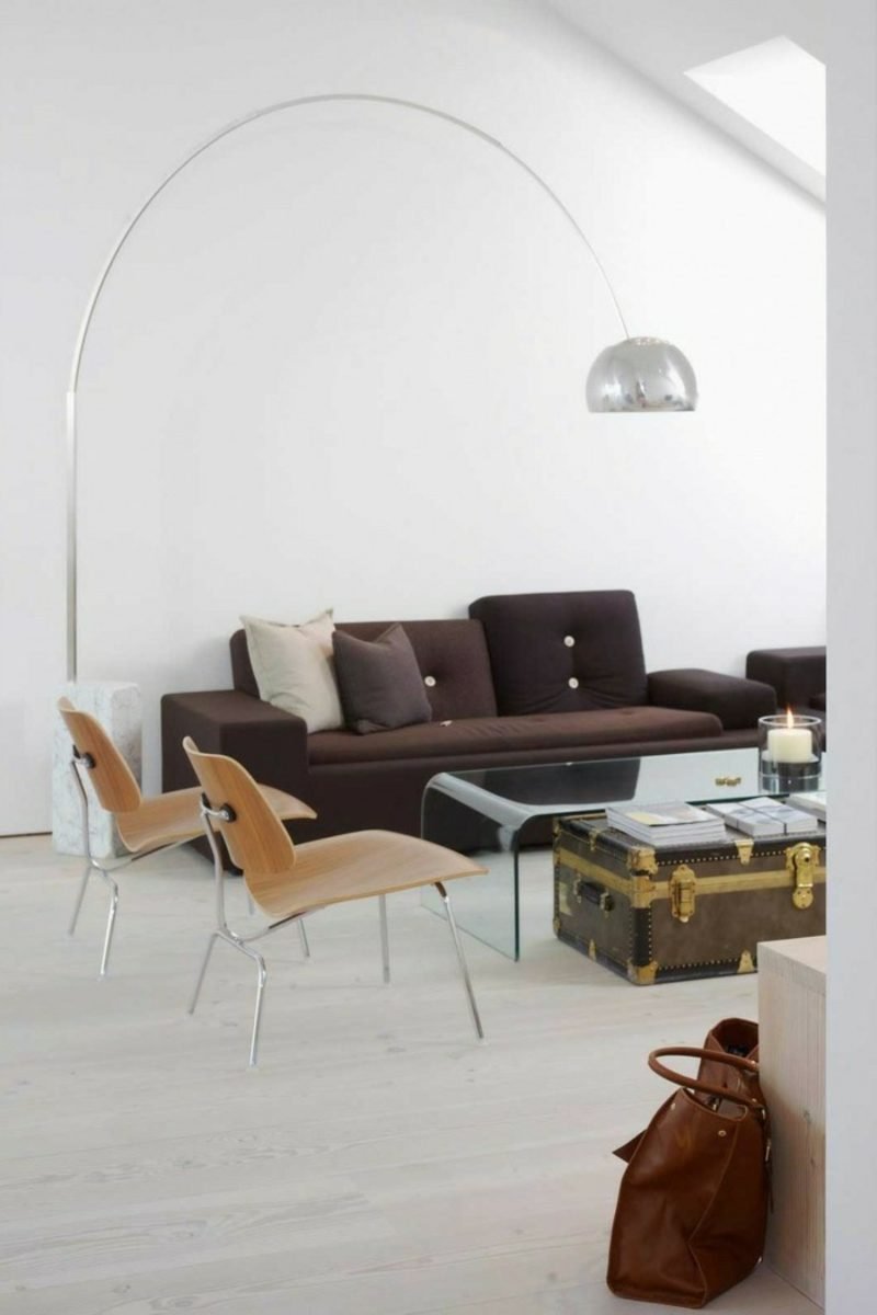 Arredi scandinavi, morbido divano color cioccolato, lampada moderna in acciaio, un tavolo originale ricavato da una vecchia valigia Divano imbottito morbido di mobili scandinavi in lampada originale marrone cioccolato realizzata con tavolino da caffè in acciaio inossidabile da vecchia valigia