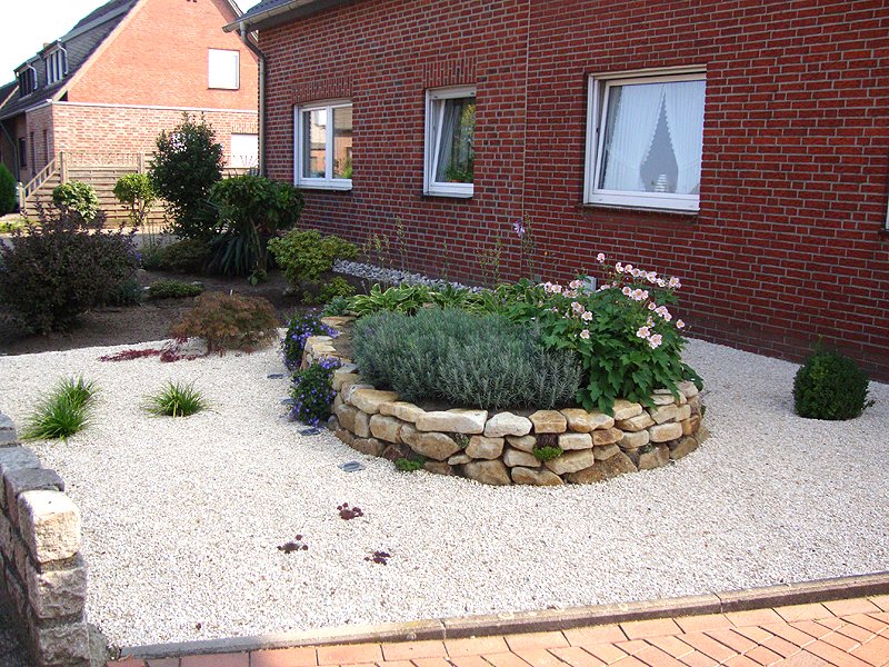 Conception de jardin avant, ordre clair, délimiter les parterres de fleurs La conception du jardin avant fait ressortir les parterres de gravier